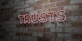 TRUSTS - Glowing Neon Sign on stonework wall - 3D rendered royalty free stock illustration