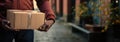 Trustworthy hands of delivery: Detailed shot of the courier& x27;s hands securely holding a parcel, instilling confidence