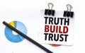 truth build trust on notebook with charts and pencil
