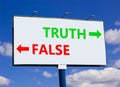 Truth or false symbol. Concept word Truth or False on beautiful billboard with two arrows. Beautiful blue sky with clouds