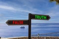 Truth or false symbol. Concept word Truth or False on beautiful signpost with two arrows. Beautiful blue sea sky with clouds