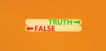 Truth or false symbol. Concept word Truth or False on beautiful wooden stick. Beautiful orange table orange background. Business
