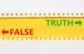 Truth or false symbol. Concept word Truth or False on beautiful yellow paper. Beautiful white paper background. Business and truth