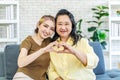 In truth, a family is what you make it. Shot of happy smiling asian senior mother and daughter making a heart sign with their Royalty Free Stock Photo