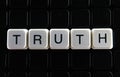Truth text word title caption label cover backdrop background. Alphabet letter toy blocks on black reflective background.