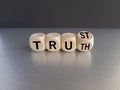 Truth or trust symbol. Turned wooden cubes and changes the word Truth to Trust. Beautiful black background, grey table. Business Royalty Free Stock Photo