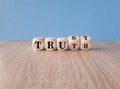 Truth or trust symbol. Turned wooden cubes and changes the word Truth to Trust. Beautiful blue background, wooden table. Business Royalty Free Stock Photo