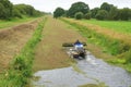 Amphibious harvester clearing weed on waterway