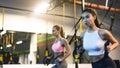 TRX training. Girls exercising with suspension trainer in the gym