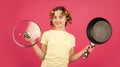 Try this. girl with curlers in hair. Fashion home shot. Pin-up style. Girl Holding Frying Pan. Little homemaker holding