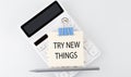 TRY NEW THINGS text on the sticker on white calculator Royalty Free Stock Photo