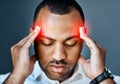 Try not to let the stress overpower your success. Studio shot of a young businessman suffering with a headache against a