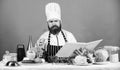 Try something new. Cookery on my mind. Cooking skill. Book recipes. According to recipe. Man bearded chef cooking food Royalty Free Stock Photo