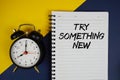 Try Something New text written on notepad with alarm clock on yellow background Royalty Free Stock Photo