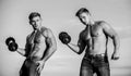 Try to lift more than last time. Muscular twins. Men brothers muscular guys sky background. Strong muscular athlete