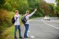 Try to stop some car. Reason people pick up hitchhikers. Missed their bus. Need help. Cheap transport. Transport problem Royalty Free Stock Photo