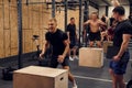 Trying hard. Young sportive man doing cardio exercises by jumping on the wooden box Royalty Free Stock Photo