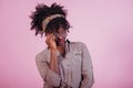 Trying on new glasses. Attractive afro american woman in casual clothes at pink background in the studio Royalty Free Stock Photo