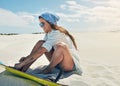 Trying out sand boarding for the very first time. a young woman sand boarding in the desert.