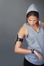 Trying to beat her best. a sporty young woman checking the time on her sports watch against a gray background. Royalty Free Stock Photo