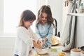 Trying to recreate what they were taught. Preschool friends learning how to cook with flour in the white kitchen Royalty Free Stock Photo