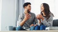 Trying to tell her to slow down on the spending. a happy young couple sitting on the sofa and talking in their living Royalty Free Stock Photo