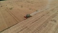 Trypillya, Ukraine - July 15, 2022: Combine harvester in the field. Harvest season. Aerial following footage view