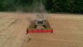 Trypillya, Ukraine - July 15, 2022: Combine harvester in the field. Harvest season. Aerial following footage view