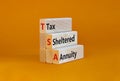 TSA, tax sheltered annuary symbol. Concept words TSA, tax sheltered annuary on wooden blocks. Beautiful orange table, orange