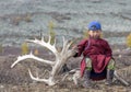 Tsaatan boy, dressed in a traditional deel with a reindeer horn