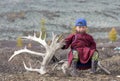 Tsaatan boy, dressed in a traditional deel with a reindeer horn