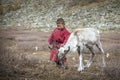 Tsaatan boy with a reindeer in a landscape of northern Mongolia Royalty Free Stock Photo