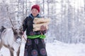 The Tsaatan people carrying firewood for fuel during the long winter in the snow.