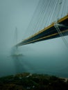 Tsing Ma suspension bridge covered with dense fog in the early morning, Hong Kong. Vertical shot