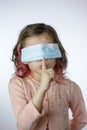 Tsss! little kid girl with mask on face showing silence gesture Royalty Free Stock Photo