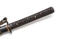 Tsuka: Handle of Japanese sword isolated in white background. Black rayskin and brown leather cord with steel fitting.