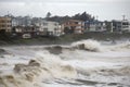 tsunami waves crash onto shore and breach coastal dikes, causing flooding and destruction