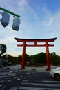 Tsurugaoka Hachimangu shrine red tori gate. Traffic light under blue sky. Modernity and history