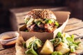 TTasty homemade burger takeaway in a box of recycled paper on wooden boards Royalty Free Stock Photo