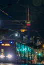 TTC street car in motion with a full moon over downtown Toronto and the CN Tower