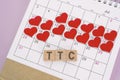 TTC word on wooden block with red heart shape on calendar. Trying To Conceive.