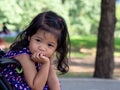 Little asian girl sitting in a stroller at public park. She have be smile and love in sign language Royalty Free Stock Photo