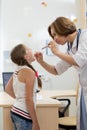 Little girl visiting pediatrician office. Doctor examining child`s throat Royalty Free Stock Photo