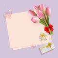 Bouquet frame of pink tulips and gift tied with gold ribbon, purple background Royalty Free Stock Photo