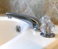 Tub faucet with stone tiles behind. Royalty Free Stock Photo