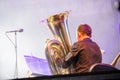 Tuba player in an orchestra on the stage, plays on big brass tube, behind the scenes shoot Royalty Free Stock Photo