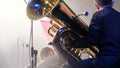 Tubaist in an orchestra on the stage, holds big brass tube, behind the scenes shoot
