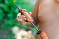 Tubby boy with pleasure eats a shish kebab. Camping. Healthy nutrition and diet. Royalty Free Stock Photo