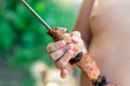 Tubby boy with pleasure eats a shish kebab. Camping. Healthy nutrition and diet. Royalty Free Stock Photo