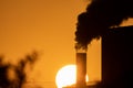 Tube with black smoke and huge sunset in the background